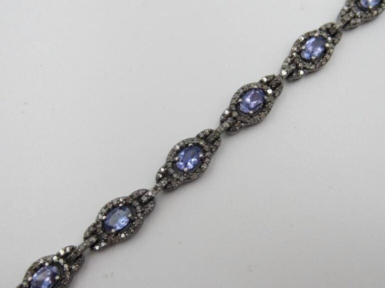 BRACELET articulé en argent noirci (925 millièmes) ajouré, serti de tanzanites de forme ovale, entourées de diamants 8      8 (manques et égrisures)             Long        : 19 cm        Poids brut : 16,5 g