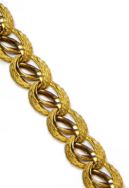 Bracelet articulé en or deux tons 18K (750°/00) à motif d'enroulements végétaux ajourés et ciselé
