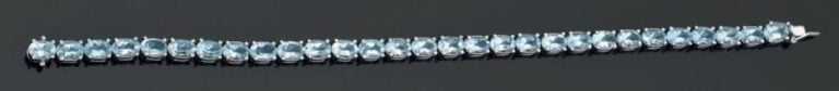 BRACELET articulé en or gris 14 carats (585 millièmes) serti d'un alignement d'aigues-marines de forme oval