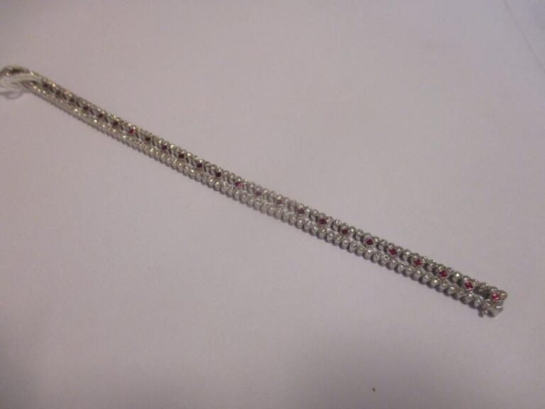 Bracelet articulé en or gris 18K (750°/00) serti de diamants ronds taillés en brillant (3,30 cts environ en tout) composé de deux lignes séparées par des rubis carrés facetté