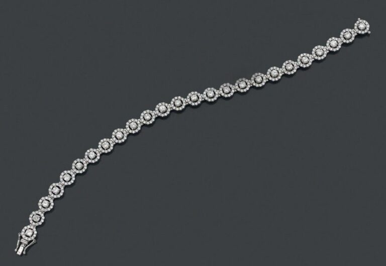 BRACELET articulé en or gris (750 millièmes) serti de 25 diamants entourés de petits diamants taille brillan
