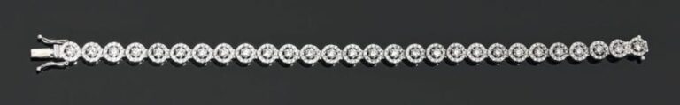 BRACELET articulé en or gris à motifs circulaires serti de diamants taille brillants entourés de petits diamant