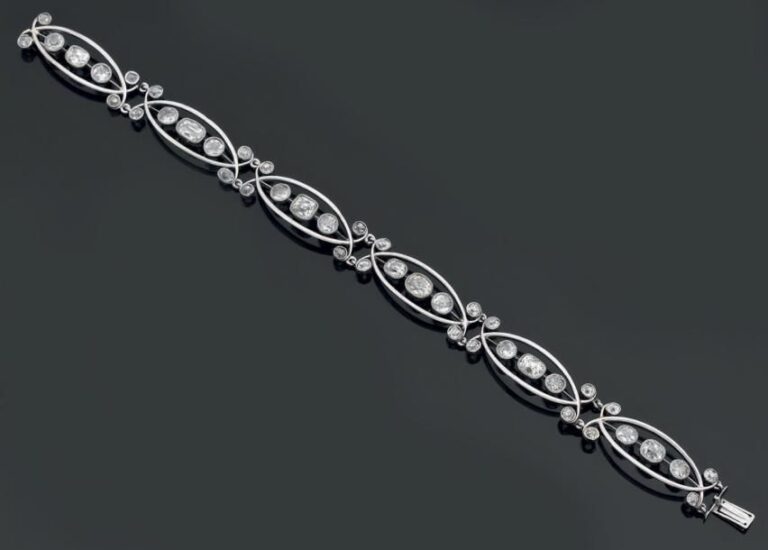 BRACELET articulé en or gris ajouré serti de diamants de taille ancienne de différentes formes à motifs de navettes et volute
