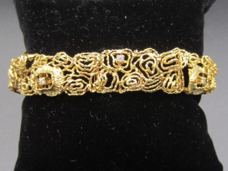 BRACELET articulé en or jaune (750 millièmes) martelé et godronné, ajouré à motifs de «roses stylisées », rehaussé de huit petits diamants taille brillan
