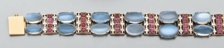BRACELET articulé en or jaune et argent ajourés, sertis de pierres de lune cabochons et rubis ronds (égrisures
