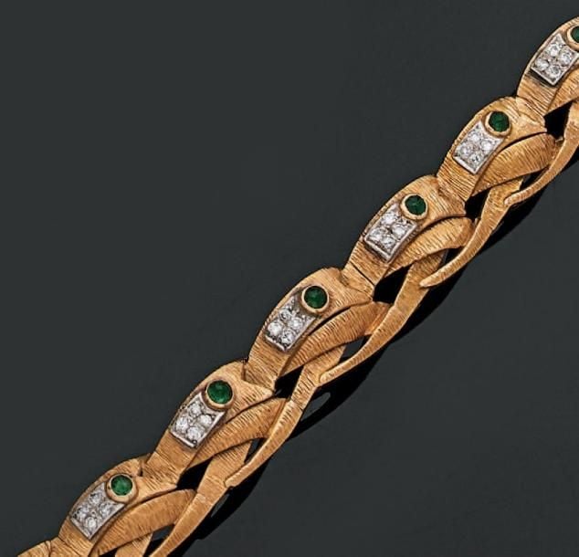 BRACELET articulé en or jaune et or gris ajouré et ciselé, serti de onze émeraudes cabochons (égrisures) et de petits diamant