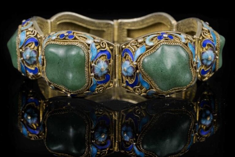 BRACELET ARTICULE EN VERMEIL  Chine, Vers 1900 A six pans, quatre garnis de cabochons de verre imitant le jade jadéite, tous ornés d'un décor filigrané délicat rehaussé d'émaux polychromes dans les tons bleu