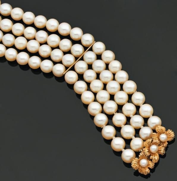 BRACELET composé de quatre rangs de perles de culture blanches retenus par deux barrettes en o