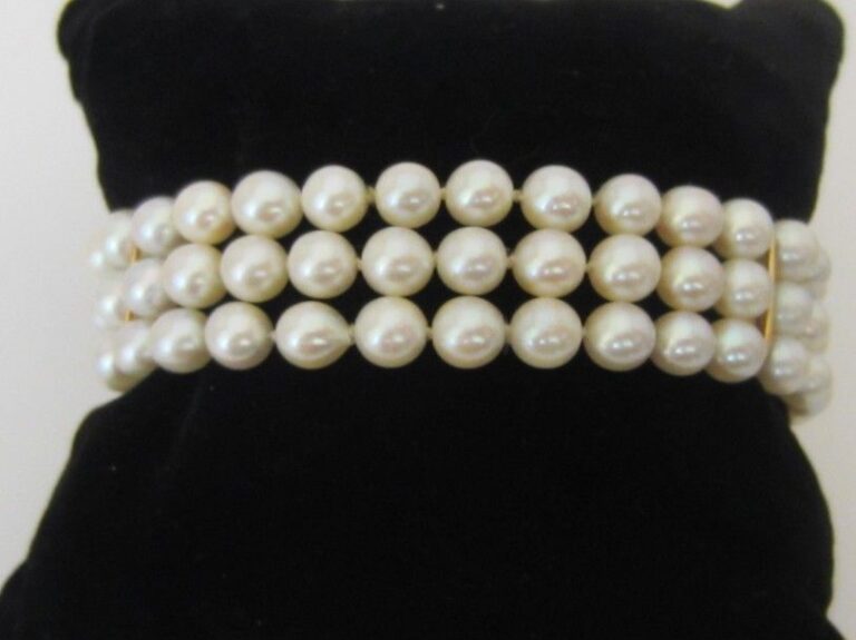 BRACELET composé de trois rangs de perles de culture blanches retenues par deux barrette