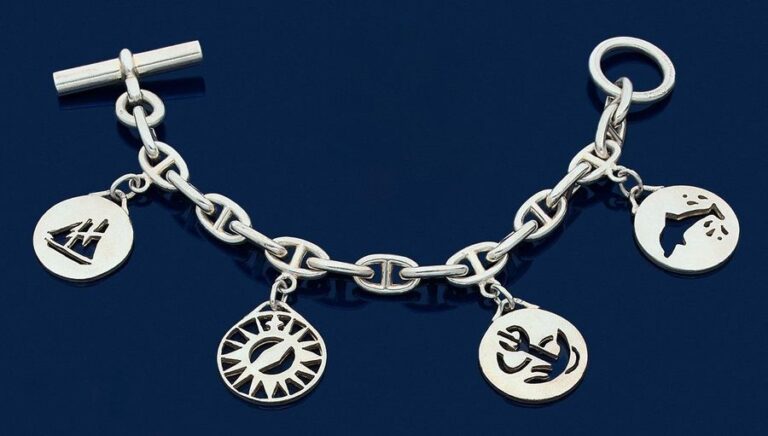 •BRACELET en argent (925‰) composé d'une «chaîne d'ancre» retenant 4 médaillons circulaires ajourés sur le thème de la mer, en pampill