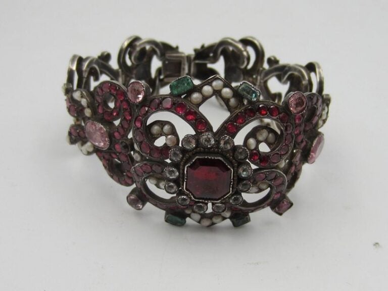 BRACELET en argent ajouré à volutes serties de perles, grenats et pierres de couleu