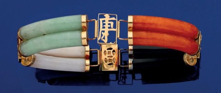BRACELET en or 14 carats (585 millièmes) ajouré et articulé, composé de quatre motifs ponts en jade vert, noir, blanc et orange alternés de motifs rectangulaires découpés et ajourés, à motifs d'inscriptions chinoises Fermoir clique