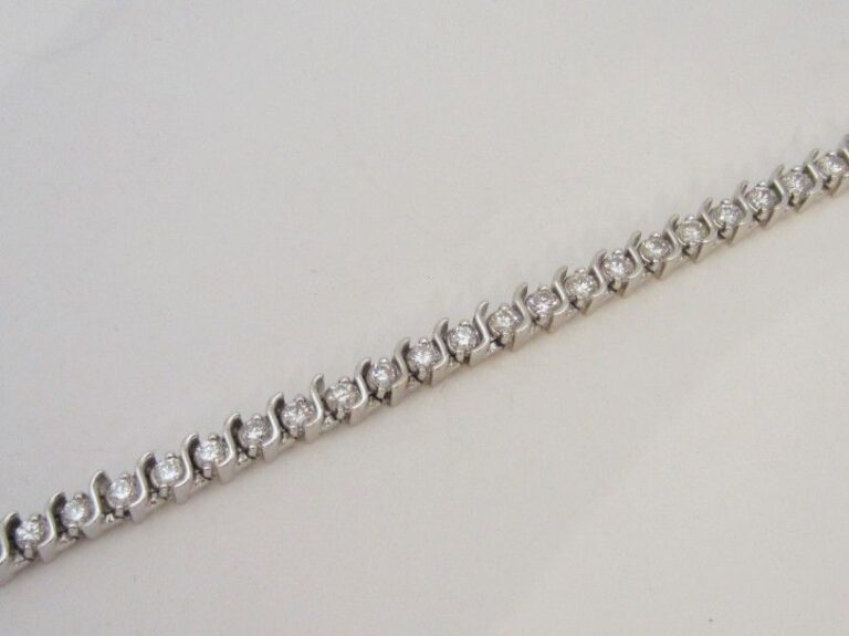 BRACELET en or gris 14 carats (585 millièmes) à motifs sinueux serti d’un alignement de 42 diamants taille brillan