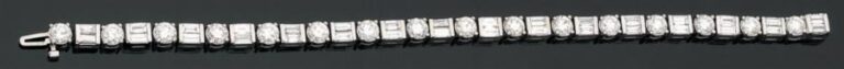 BRACELET en or gris 14 carats (585 millièmes) articulé, serti de 16 diamants taille brillant et baguettes alterné