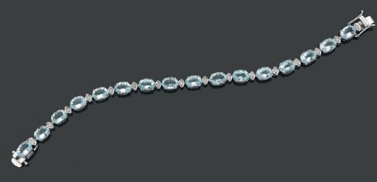 BRACELET en or gris 14 carats (585 millièmes) serti d'aiguesmarines de forme ovale alternées de petits diamants taille brillan