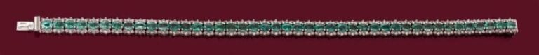 BRACELET en or gris 14 carats (585 millièmes) serti d'une ligne d'émeraudes ovales soulignée de petits diamants taille brillan