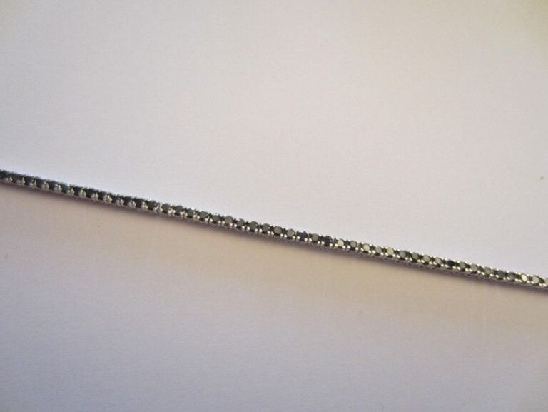 BRACELET en or gris 14 carats (585 millièmes) serti d?une ligne de petits diamants noirs taille brillan