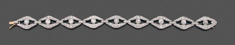 •BRACELET en or gris (750‰) ajouré, à motifs navettes serti de diamants taille brillant et taille ancienne, dont neuf plus important