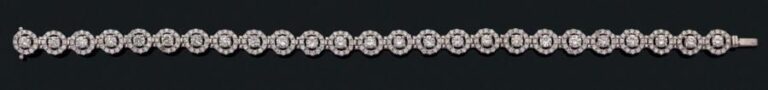 BRACELET en or gris (750 millièmes) articulé composé de 25 motifs circulaires ajourés sertis de diamants taille brillant, les centres plus important