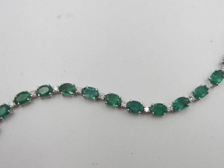 BRACELET en or gris (750 millièmes) serti de vingt émeraudes de forme ovale alternées de diamants taille brillan