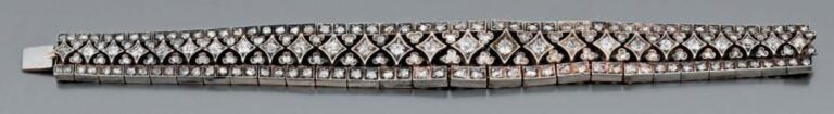 BRACELET en or gris et argent ajouré et articulé à motifs losangiques et trèfles, serti de diamants taille ancienne et taillés en rose, en chut
