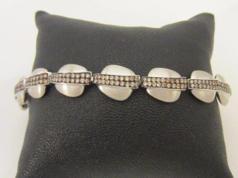 BRACELET en or gris et or noirci (750 millièmes) brossé, composé d’un alignement de motifs de forme coussin surmontés de pavages de diamants brun