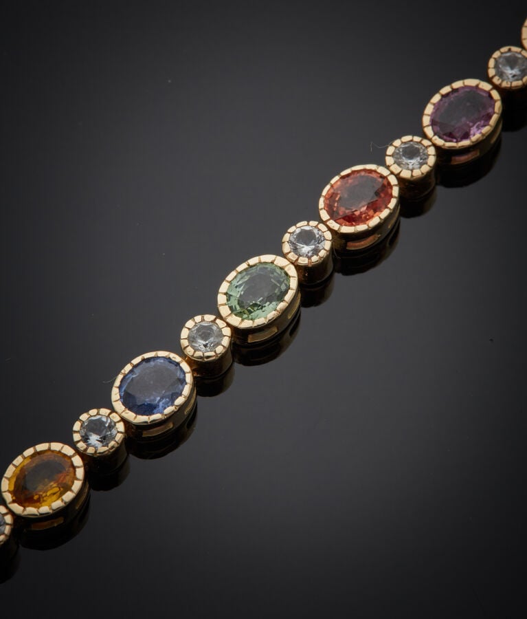 BRACELET en or jaune (375‰) 9 carats, articulé, serti de saphirs multicolores o…