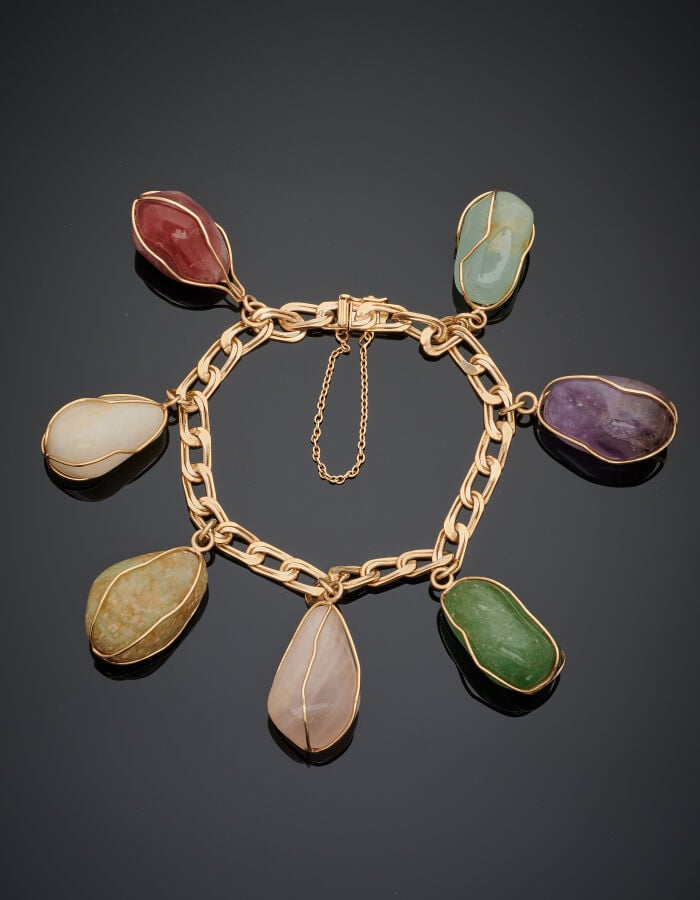 BRACELET en or jaune (750‰) à maille gourmette, retenant sept pierres ornementa…