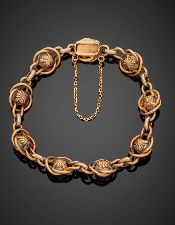 BRACELET en or jaune (750‰) à maillons entrelacés, orné de huit perles (non tes…