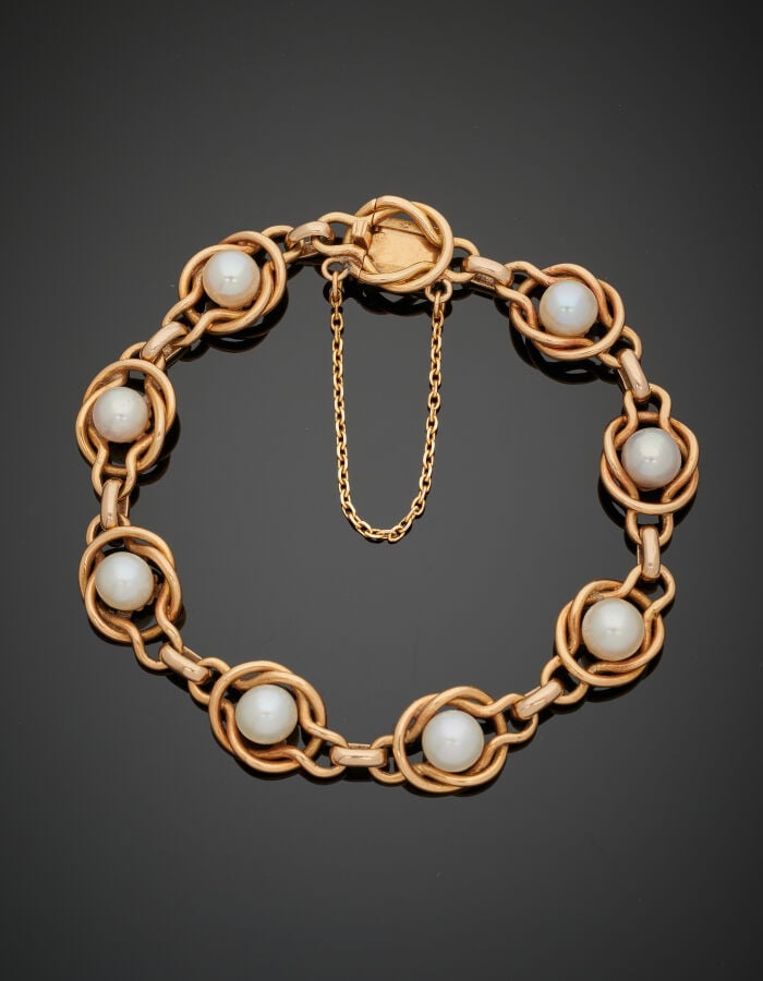 BRACELET en or jaune (750‰) à maillons entrelacés, orné de huit perles (non tes…