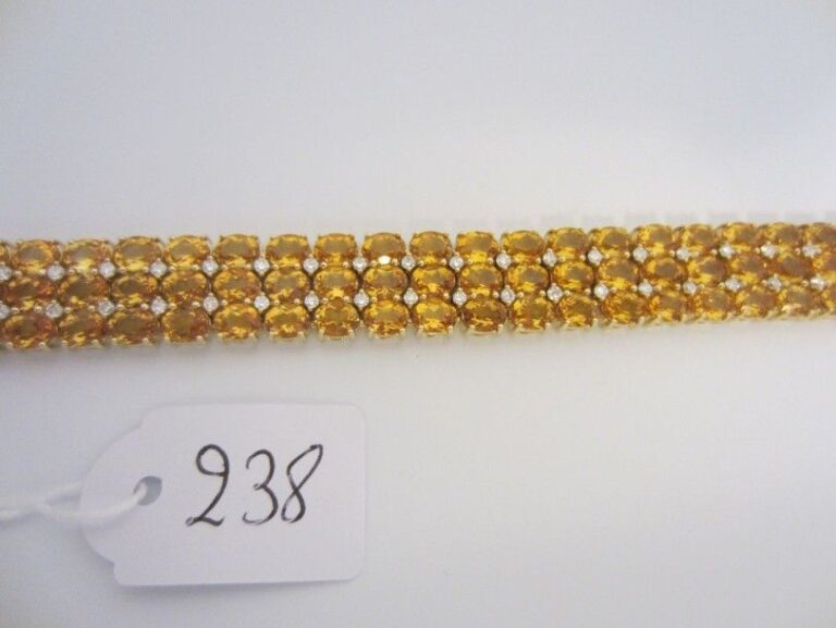 BRACELET en or jaune (750 millièmes) articulé serti de trois lignes de citrines ovales ponctuées de diamants taille brillan