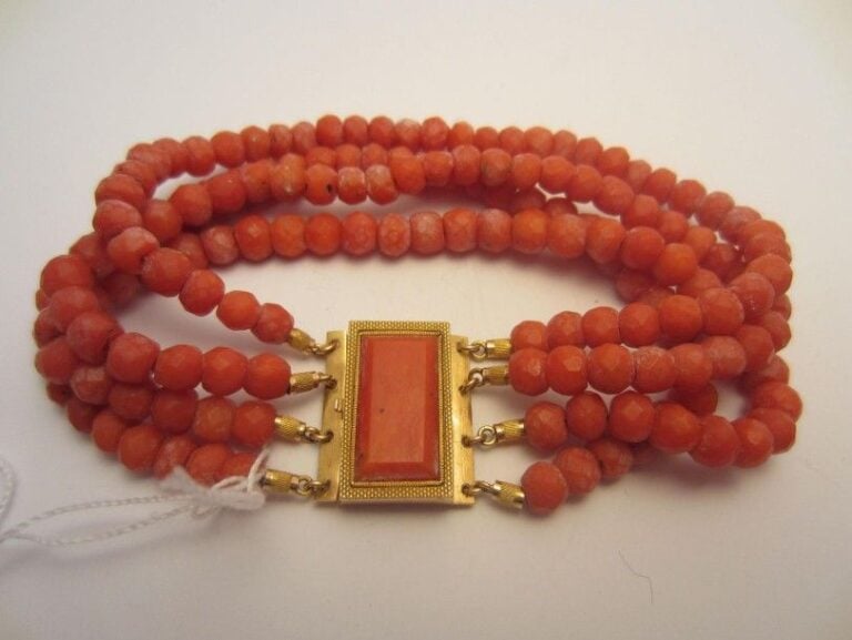 BRACELET en or jaune (750 millièmes) composé de quatre rangs de perles de corail facett