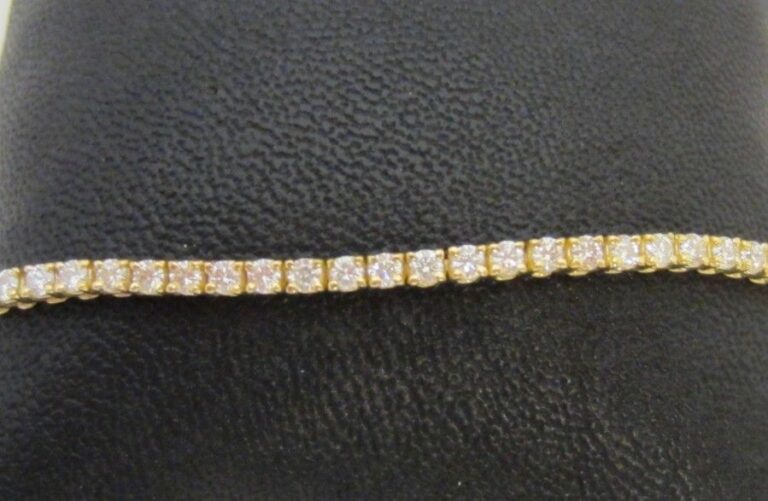 BRACELET en or jaune (750 millièmes) composé d’une double chaînette retenant un alignement de 30 petits diamant