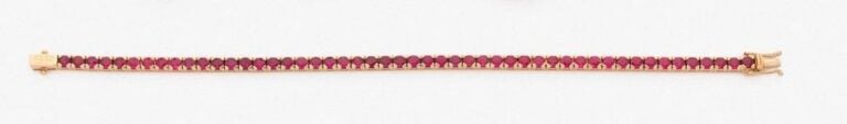 •BRACELET en or jaune (750‰) serti d'un alignement de rubis rond