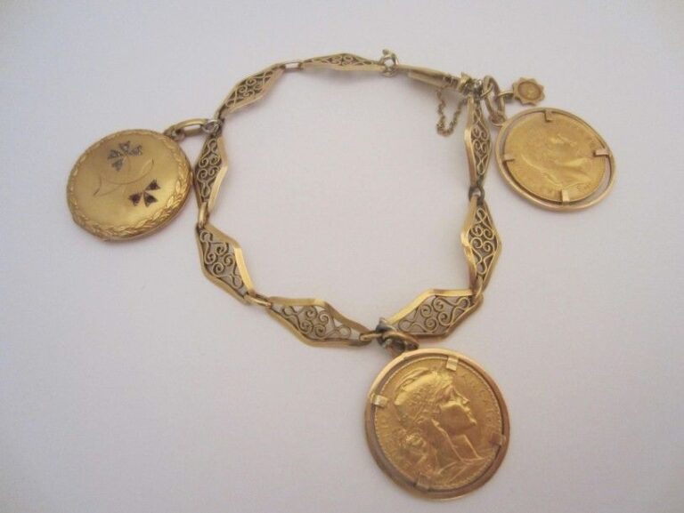 Bracelet en or jaune ciselé à maillons losangiques (750 mill) avec un médaillon circulaire en or jaune à motif de fleurettes et deux pièces de 20 francs or montées en pendentif