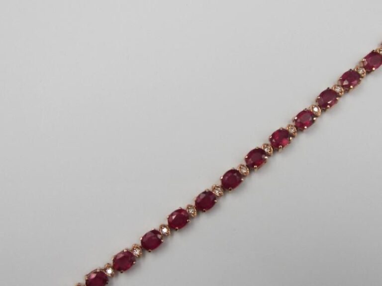 BRACELET en or rose (585 millièmes) 14 carats, serti d'un alignement de rubis traités de forme ovale alternés de diamant