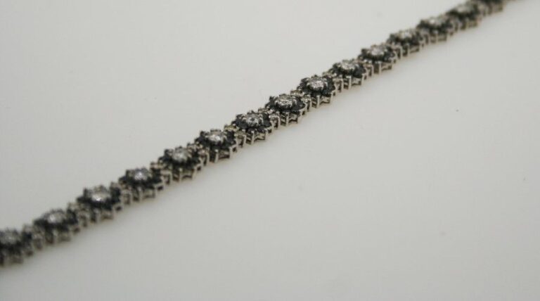 BRACELET «fleurettes» en or gris 14 carats (585 millièmes) serti de diamants blancs et noirs alterné