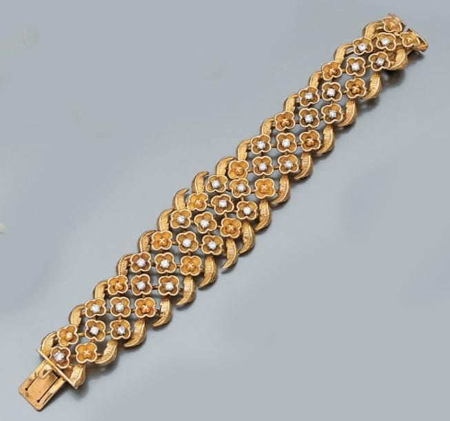 BRACELET flexible «fleurettes» en or jaune articulé partiellement ciselé et serti de diamants taille brillan