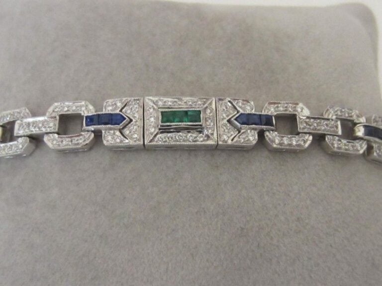 BRACELET géométrique en or gris (750 millièmes) articulé et ajouré serti de diamants taille brillant, émeraudes et saphirs calibré
