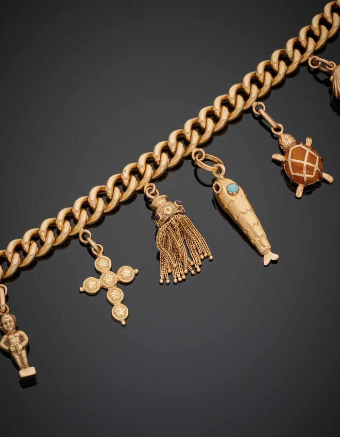 BRACELET "gourmette" en or jaune (750‰) retenant huit breloques (médaille relig…