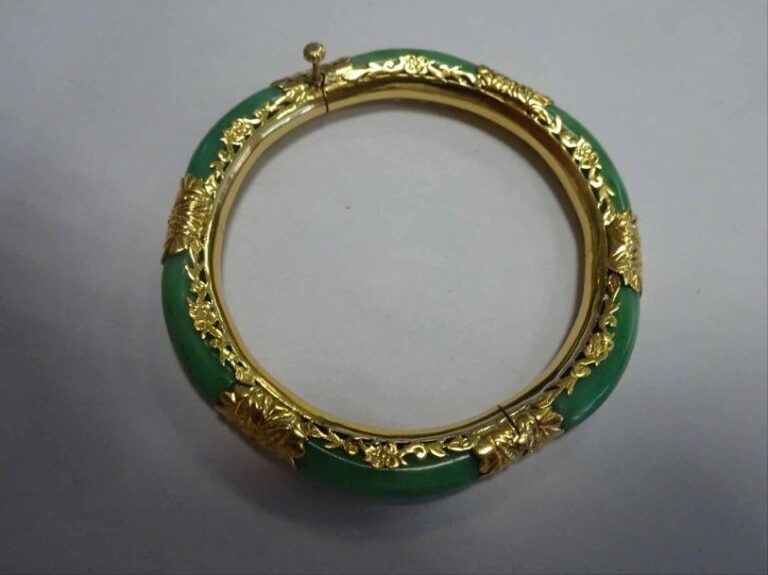BRACELET jonc en or jaune 18K (750°/00) ajouré à décor de feuillages serti de jade jadéit