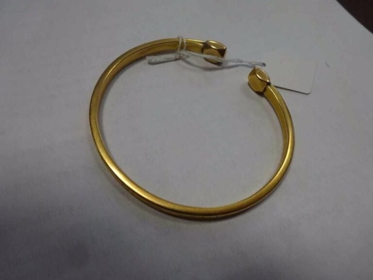 Bracelet jonc ouvert en or jaune 18K (750°/00) à décor gravé de fleurs et feuillage