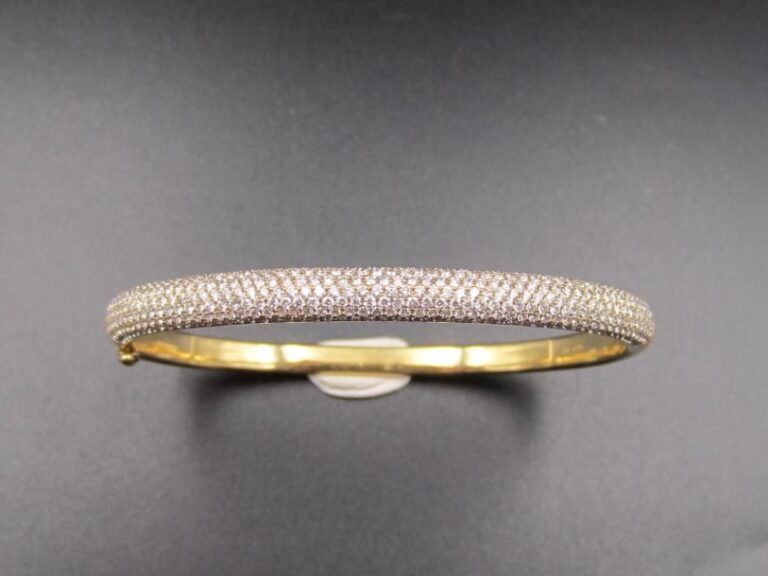 BRACELET jonc rigide ouvrant en or jaune et or gris (750 millièmes) partiellement pavé de diamants taille brillan