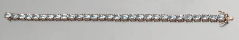 BRACELET « ligne » articulé en or rose 9 carats (375 millièmes), serti d'un alignement d'aigues-marines de forme oval