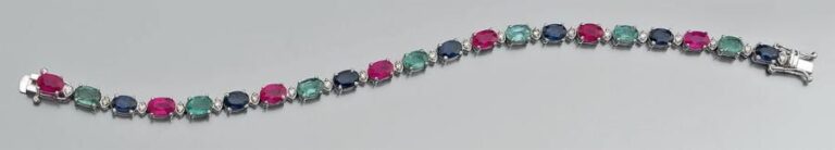 BRACELET ligne en or gris 14 carats (585 millièmes) serti de rubis, émeraudes et saphirs ovales alternés de petits diamants taille brillan