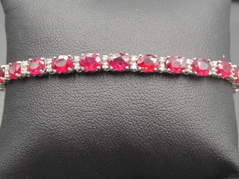 BRACELET ligne en or gris (750 millièmes) serti de 27 rubis de forme ovale, alternés de diamants taille brillan