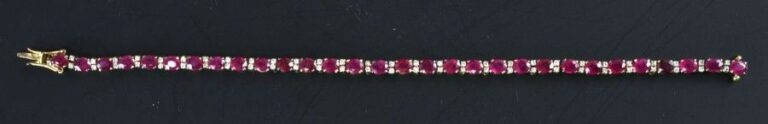Bracelet ligne en or jaune 18k (750 °/00) serti de rubis ovales (traités) entrecroisés de diamants taille brillan