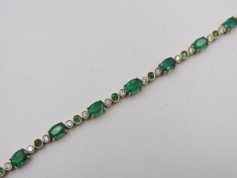 BRACELET ligne souple en or jaune et or gris (750 millièmes) serti d’émeraudes de formes ovales et rondes alternées de diamants taille brillan