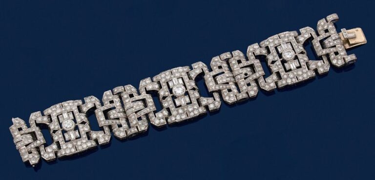 BRACELET manchette articulé en platine (950 millièmes) et or gris (750 millièmes) ajouré, à motifs géométriques, entièrement pavé de diamants ronds et baguettes, dont trois plus important