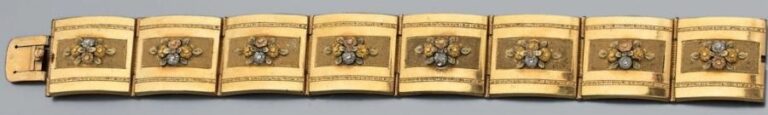 BRACELET MANCHETTE articulé en pomponne partiellement ciselé et amati rehaussé de huit motifs bouquets de fleur